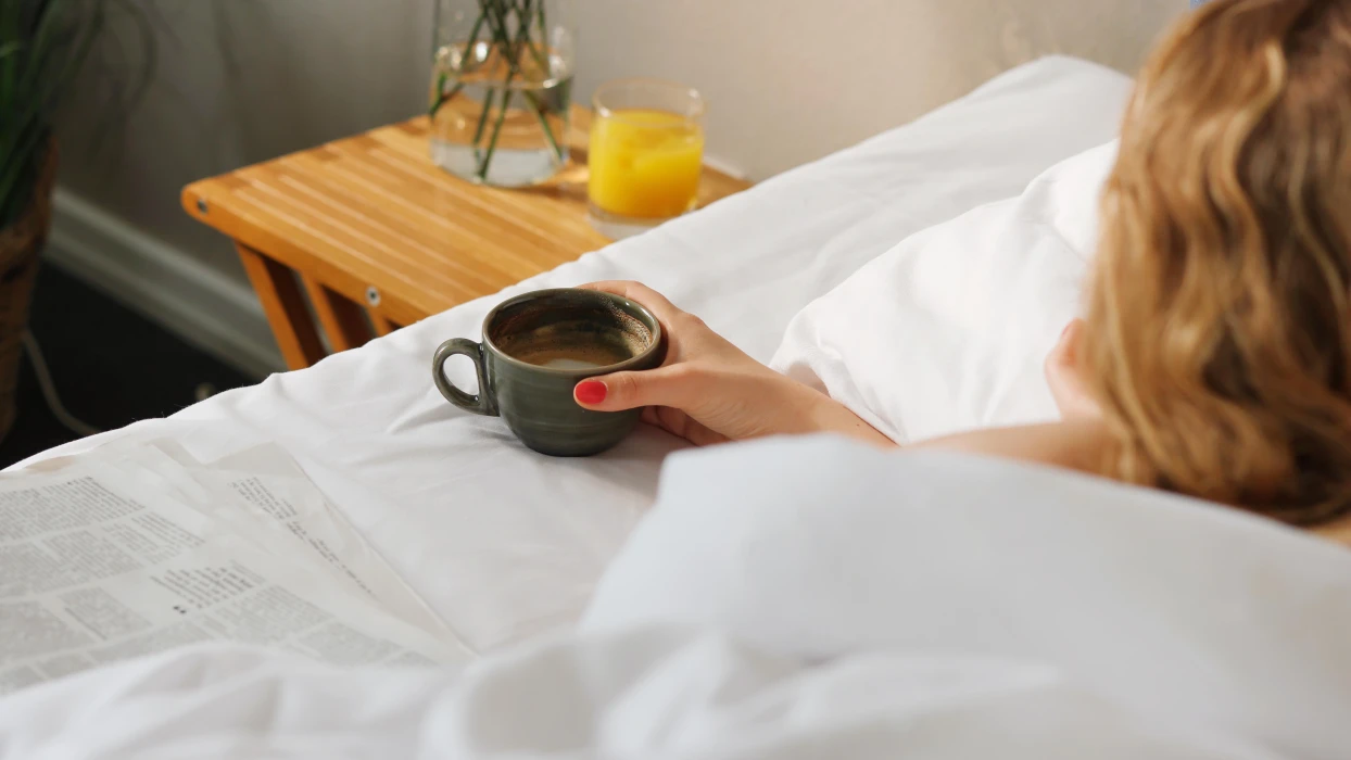 Rolig morgen med kaffe og avis i sengen på dit hotelværelse